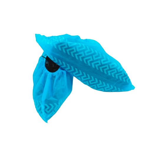 Imagen en primer plano de un cubre calzado desechable Ceamed en un vibrante color azul. El diseño destaca por su textura de tela no tejida y una trama gofrada antideslizante que recorre toda la suela para garantizar la seguridad en superficies lisas. Cuenta con una banda elástica en el tobillo para un ajuste firme y cómodo sobre cualquier zapato. Distribuido por Klinetix.